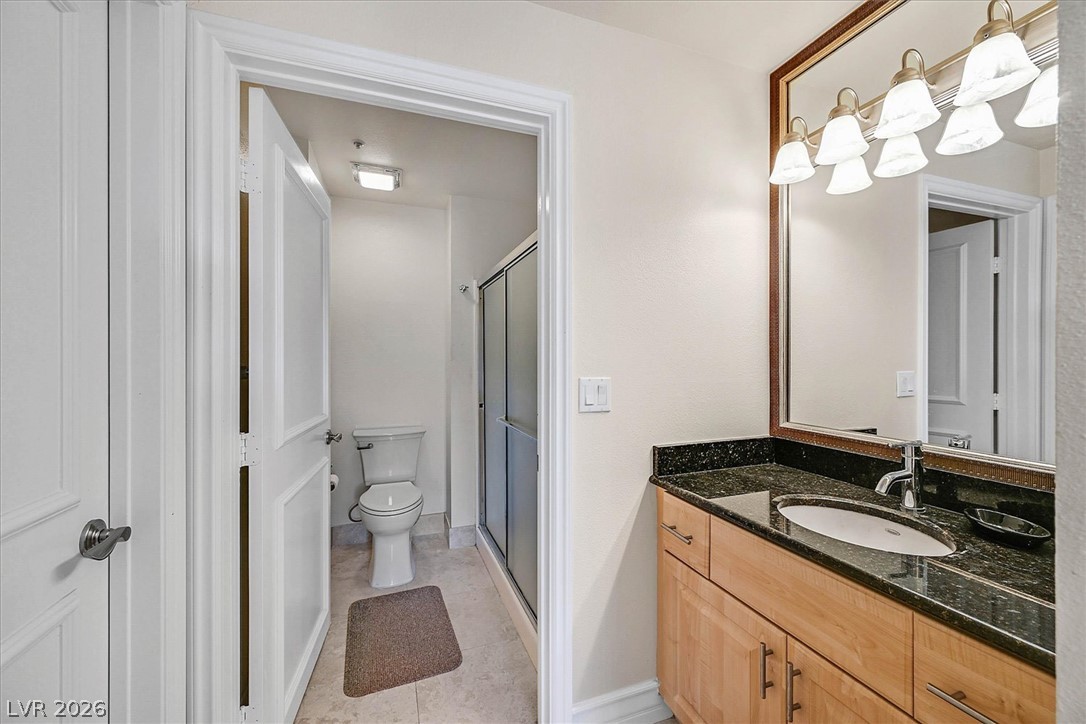 220 East Flamingo Road, Unit 305 Las Vegas, NV 89169 - Photo 11 of 26 Functional full bathroom featuring a convenient single vanity and a shower with sliding glass doors.