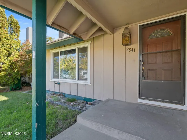 a view of a house with a yard and wooden fence