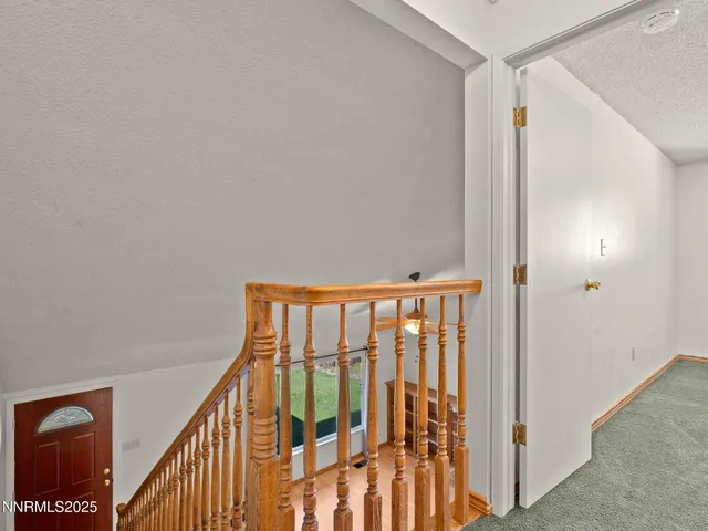 a view of staircase with railing and a chandelier
