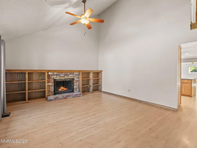 an empty room with a fireplace and fan