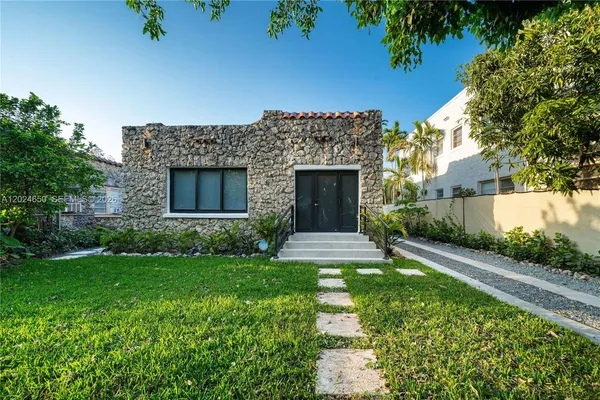 a front view of a house with a garden
