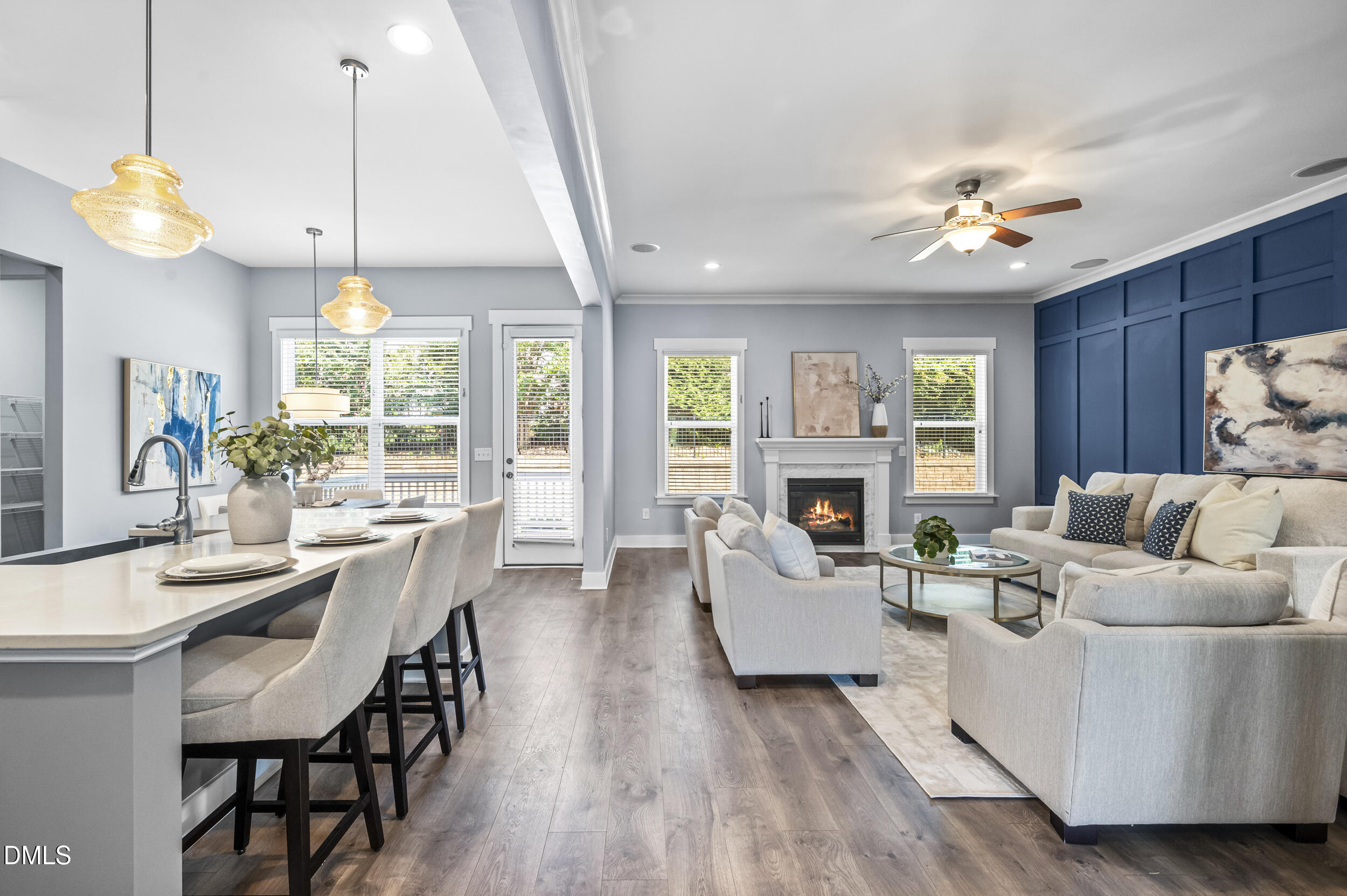613 White Oak Pond Road Apex, NC 27523 - Photo 15 of 72 Open-concept living area with wood-finish flooring, a built-in fireplace, and a kitchen island with pendant lighting