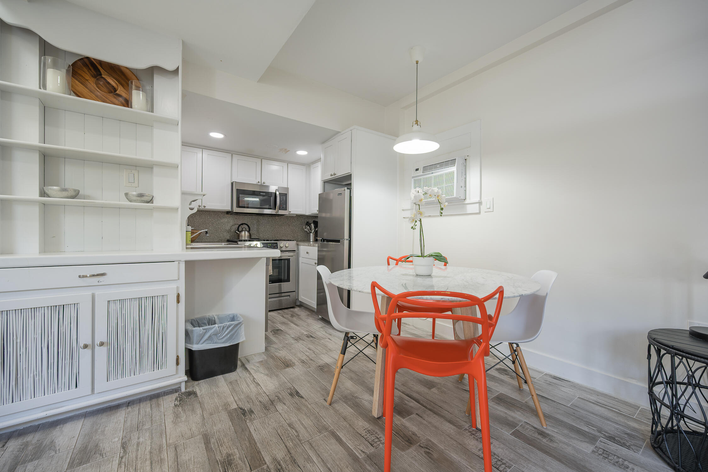 609 1/2 Margaret Street Key West, FL 33040 - Photo 3 of 35 a kitchen with a dining table chairs and white cabinets