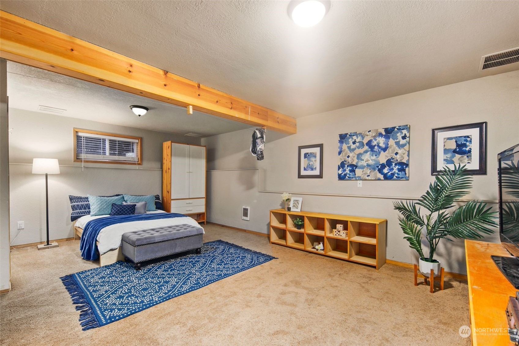 14322 Three Lakes Road Snohomish, WA 98290 - Photo 17 of 36 a spacious bedroom with a bed a couch and paintings on the wall