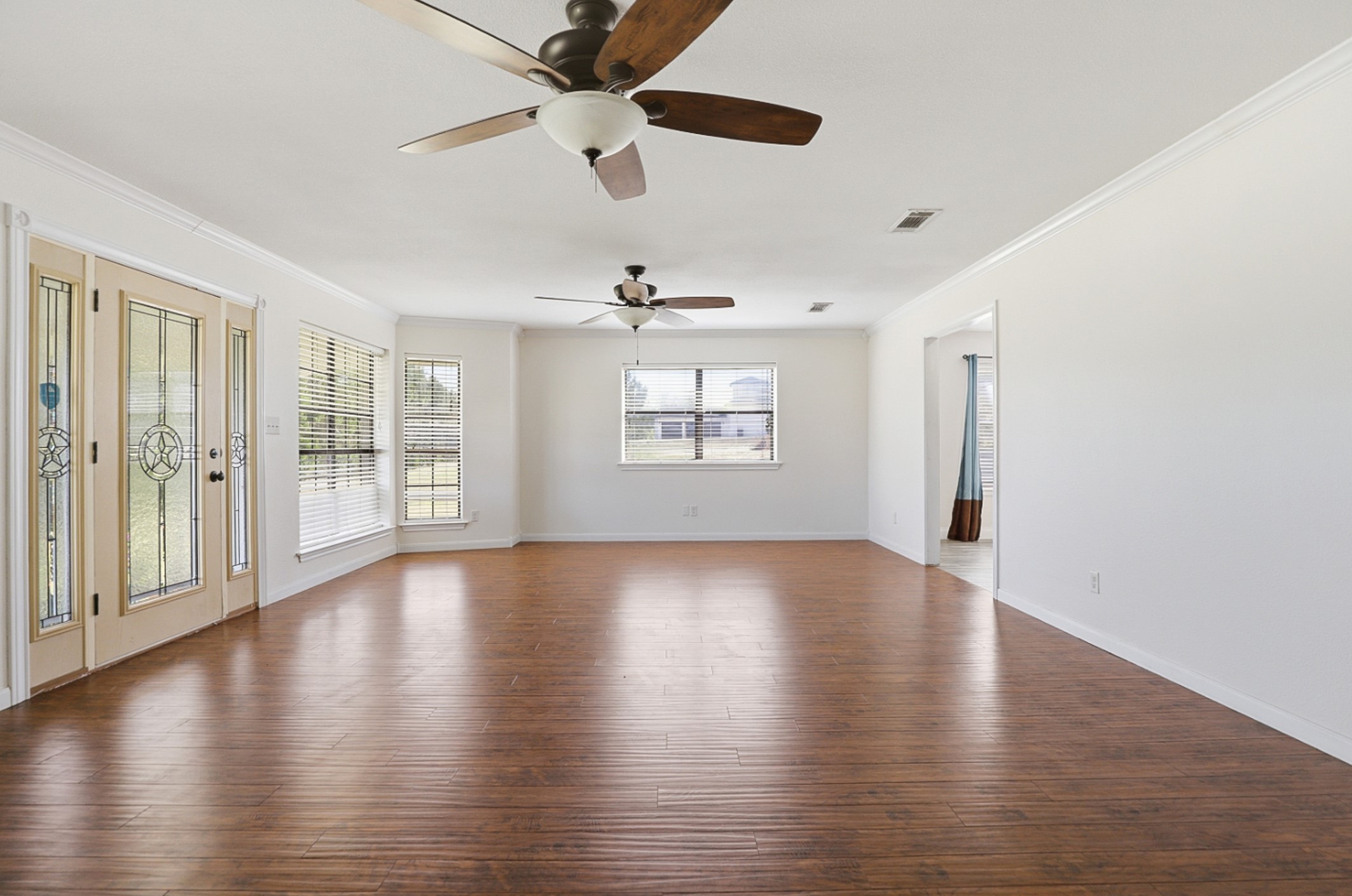 128 Skyview Terrace Leander, TX 78641 - Photo 4 of 23 Unfurnished room featuring dark wood-style flooring, ornamental molding, and a dual ceiling fans