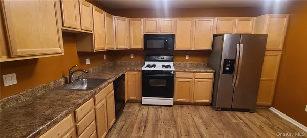 a kitchen with granite countertop a refrigerator stove and sink