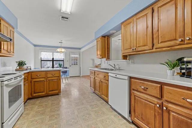 a kitchen with sink a stove and cabinets