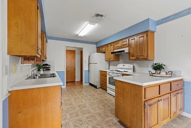 a room with chandelier fan and windows
