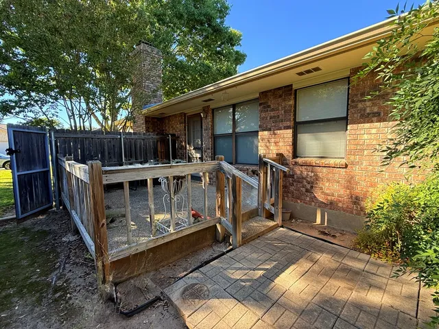 a view of a small house with backyard and furniture