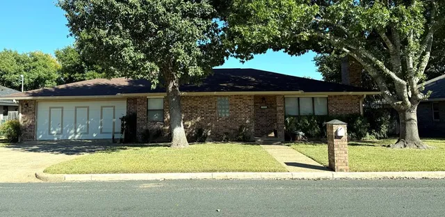 a front view of house with yard and trees