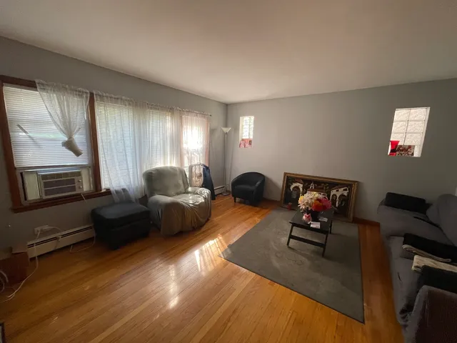 a living room with furniture and a flat screen tv with kitchen view