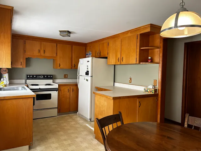 a kitchen with a refrigerator a stove and a wooden cabinets