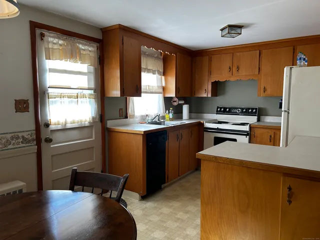 a kitchen with a refrigerator a stove a sink and a window
