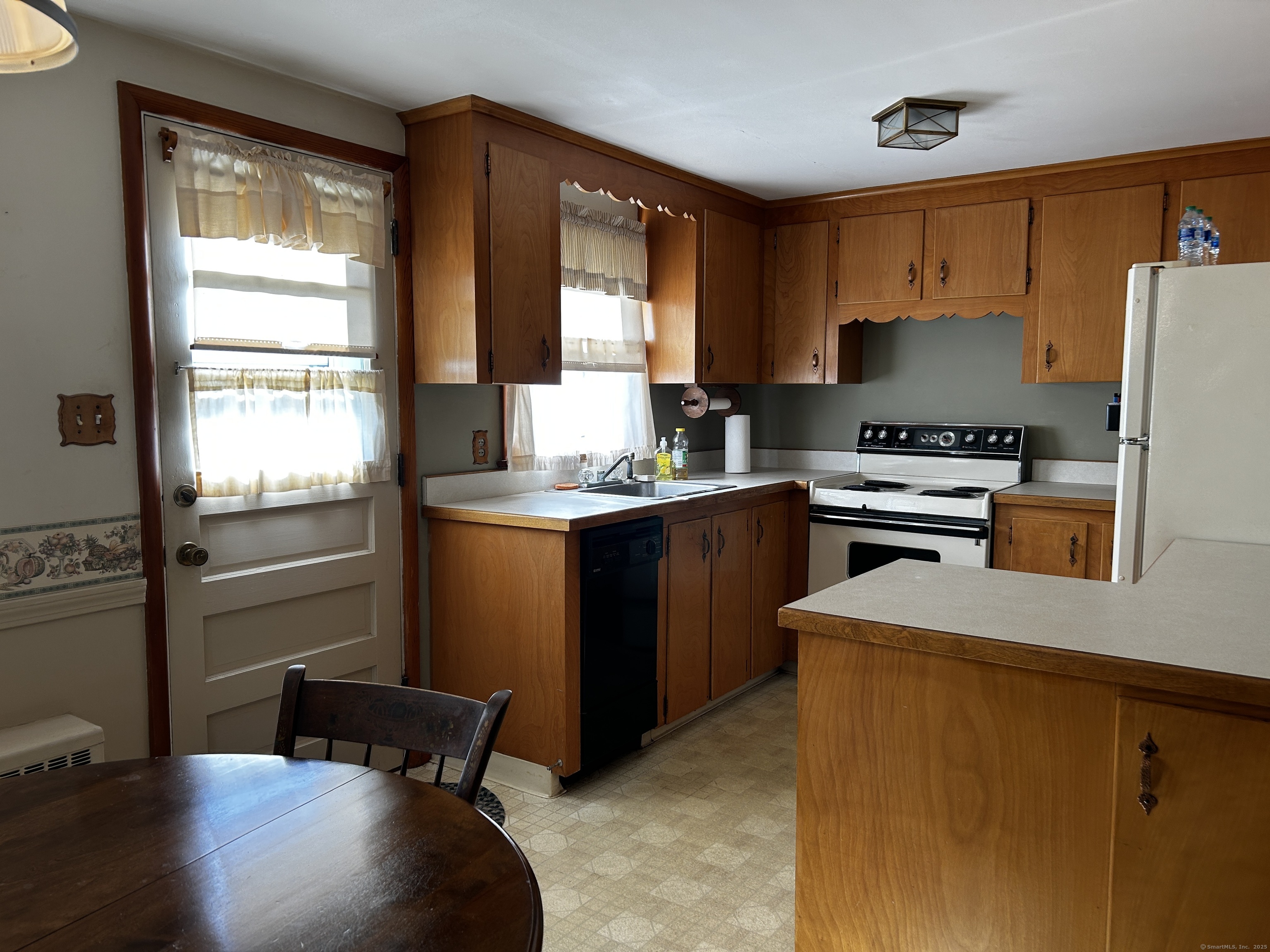 69 Wauregan Road Killingly, CT 06239 - Photo 9 of 23 a kitchen with a refrigerator a stove a sink and a window
