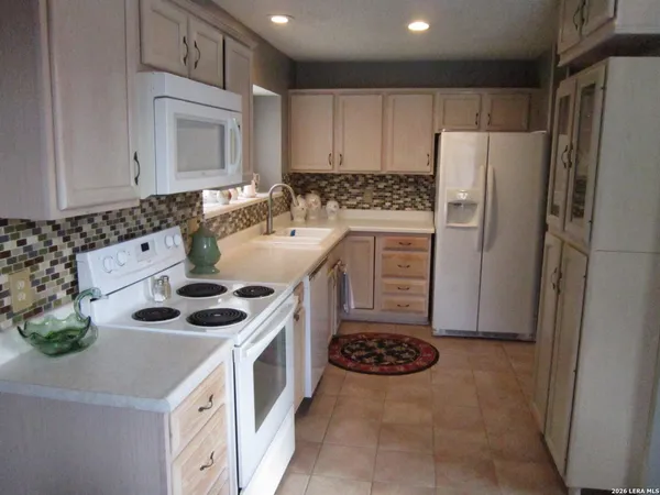 a kitchen with a stove a refrigerator and a sink
