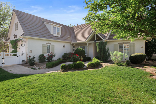 20 Valley Road Leeds, UT 84746 - Photo 26 of 57 Stucco exterior with a tiled roof, featuring decorative shutters, a gabled entry, and a white picket gate