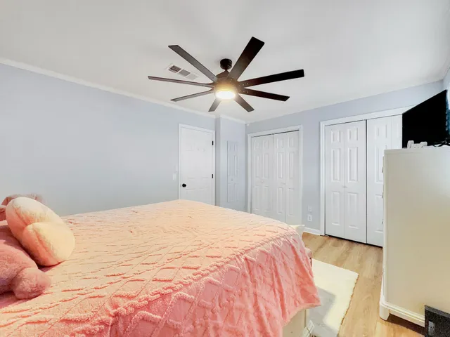 a bedroom with a bed and a ceiling fan