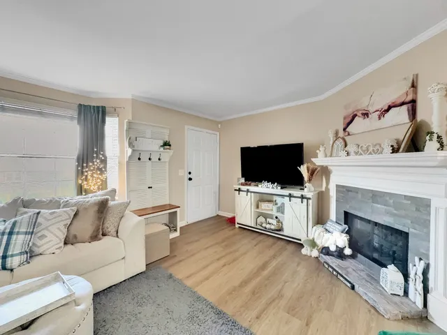a living room with furniture a flat screen tv and a fireplace