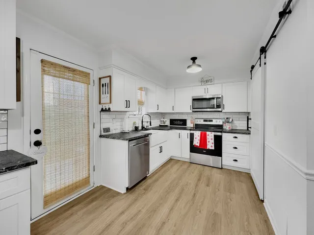 a kitchen with stainless steel appliances a stove refrigerator sink and cabinets