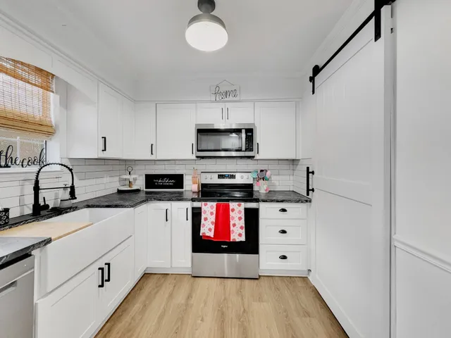 a kitchen with stainless steel appliances white cabinets and a sink