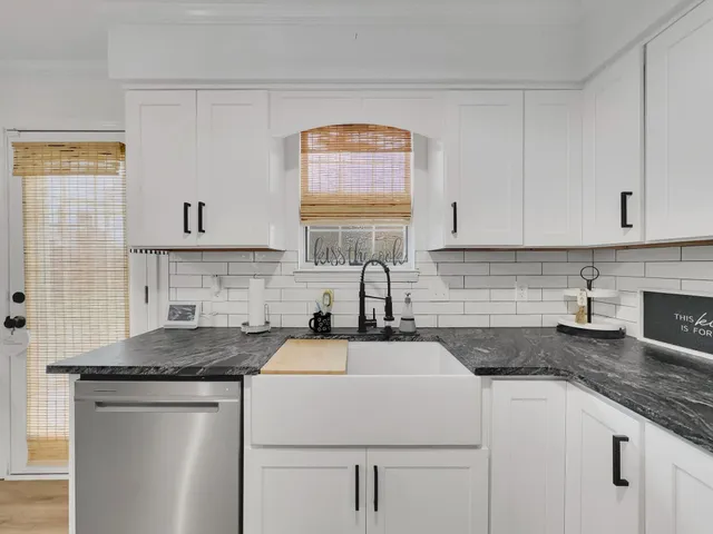 a kitchen with stainless steel appliances granite countertop a sink stove cabinets and a window