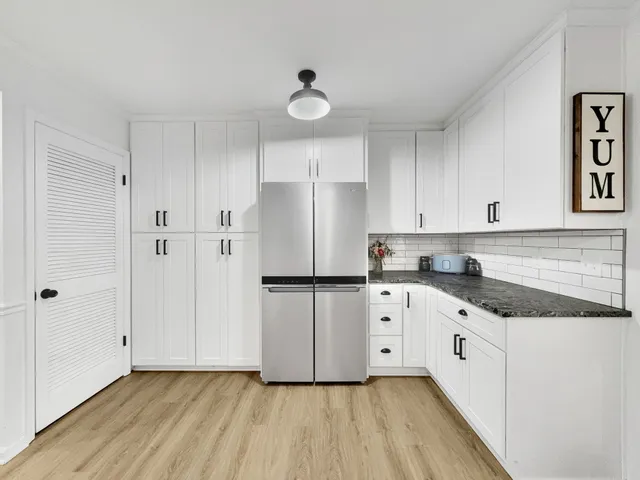 a kitchen with granite countertop white cabinets and white appliances