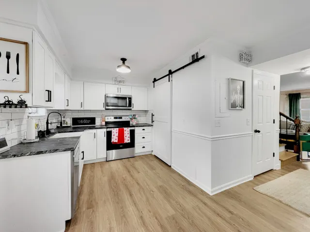 a kitchen with granite countertop stainless steel appliances and white cabinets
