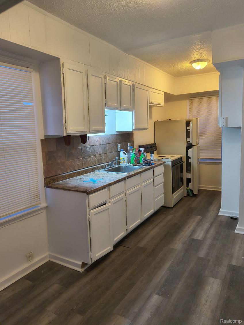 9260 Manor Detroit, MI 48204 - Photo 2 of 9 Kitchen featuring a textured ceiling, white cabinets, white appliances, and dark wood-type flooring