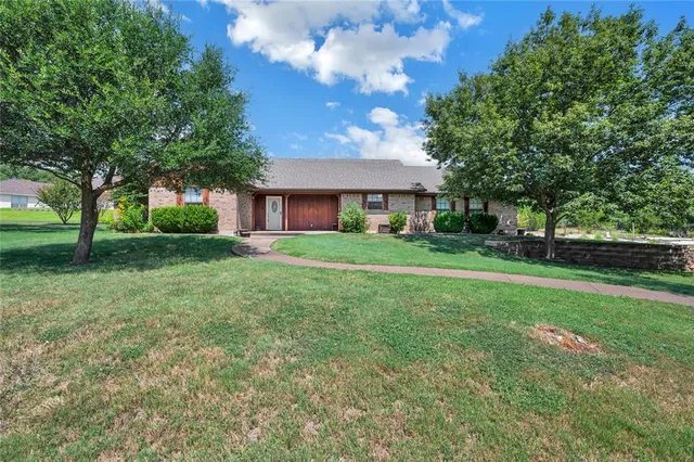 a front view of house with yard and green space