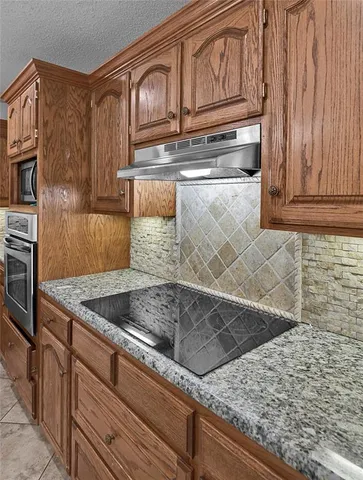 a kitchen with granite countertop a sink and a stove