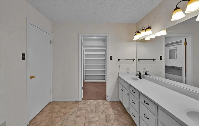 a spacious bathroom with a double vanity sink a large mirror and a shower