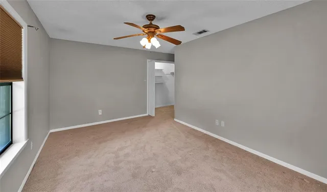 en view of an empty room with a chandelier fan
