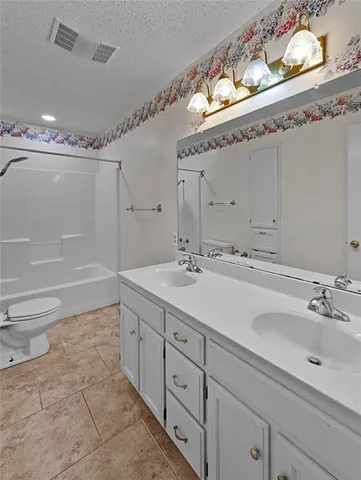 a spacious bathroom with 2 sink double vanity and a mirror