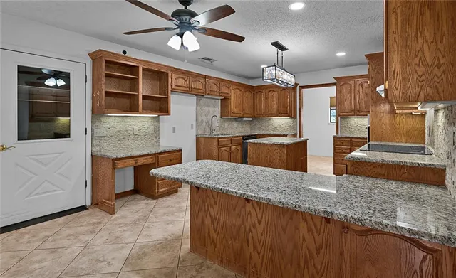 a kitchen with kitchen island granite countertop a large counter top space appliances and cabinets