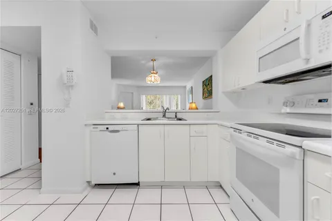 a kitchen with white cabinets appliances and sink