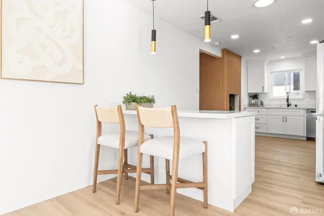 a kitchen with a dining table chairs and white cabinets