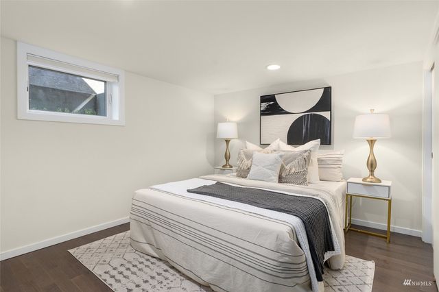 a bedroom with a bed and a lamp with the wooden floor