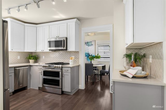 a kitchen with a stove a microwave and wooden floor
