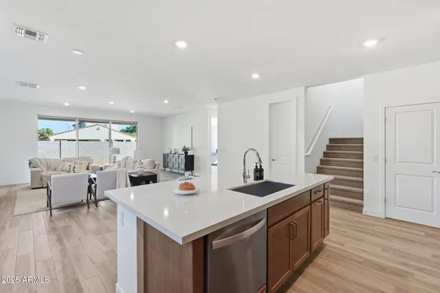 a view of kitchen island a sink and wooden floor