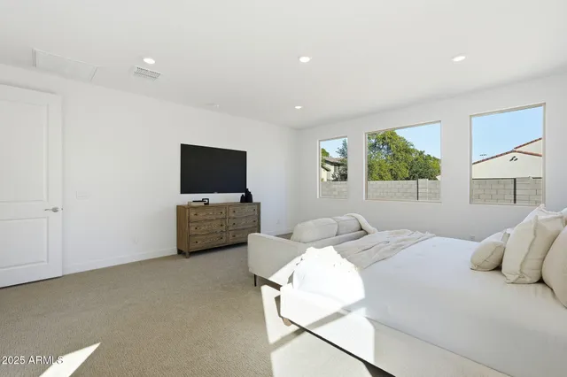 a bedroom with a bed and a flat screen tv