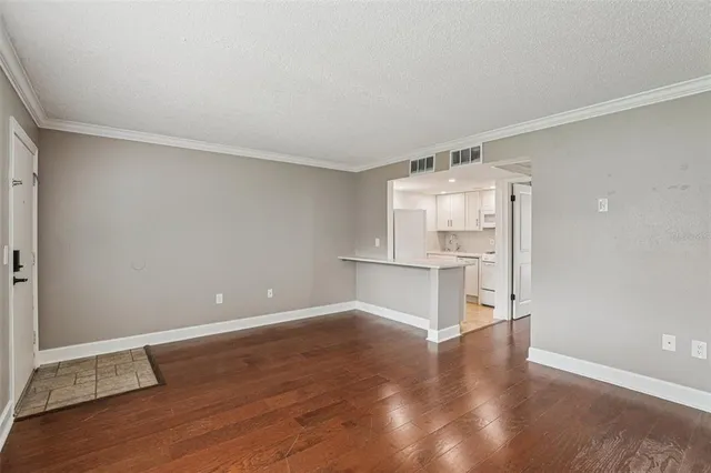 a view of empty room with wooden floor