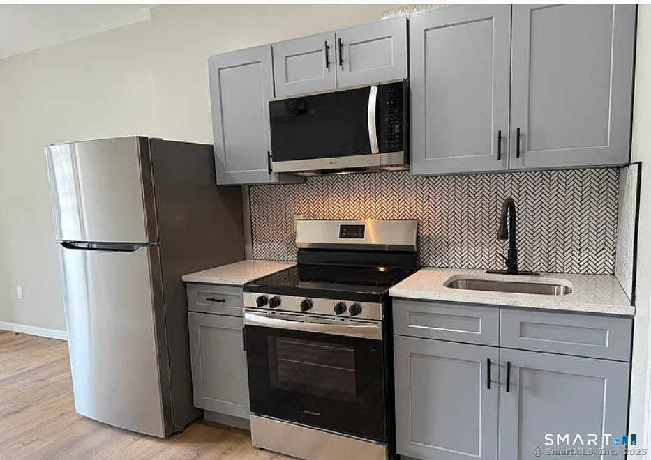 61 Field Street, Unit 106 Waterbury, CT 06702 - Photo 1 of 5 a kitchen with stainless steel appliances a stove microwave and refrigerator