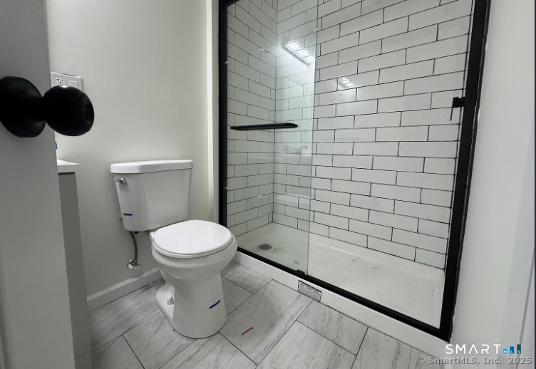61 Field Street, Unit 106 Waterbury, CT 06702 - Photo 4 of 5 a bathroom with a toilet and a shower