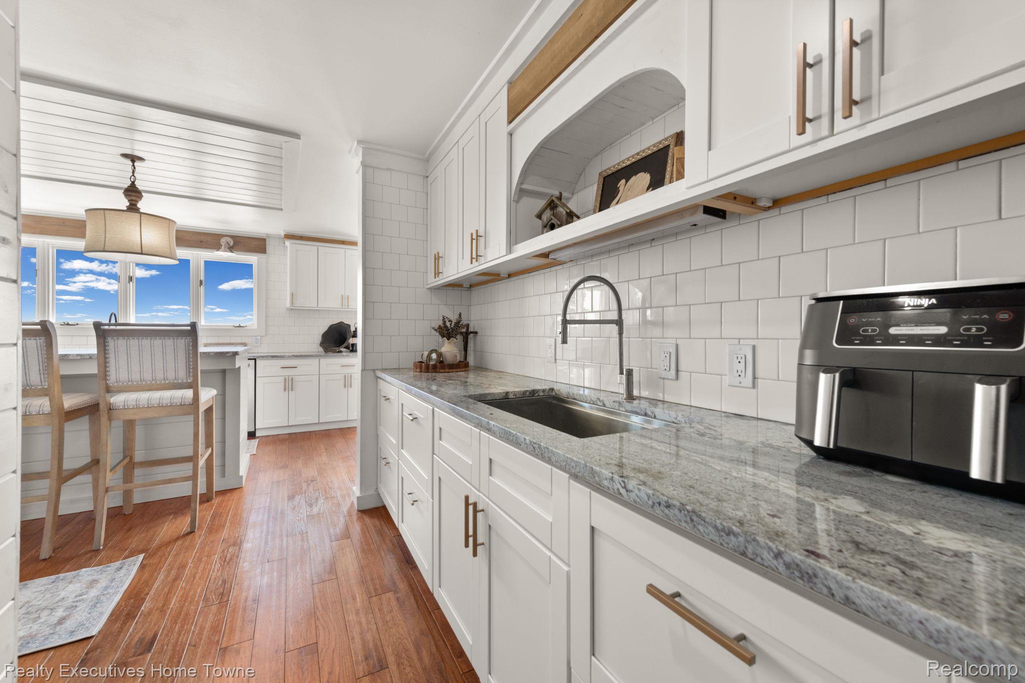 8308 Lakeshore Road Fort Gratiot, MI 48059 - Photo 39 of 79 Kitchen showcasing white shaker cabinetry, light-toned granite countertops, and a white subway tile backsplash
