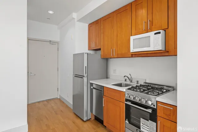 a view of a kitchen with a sink and a refrigerator