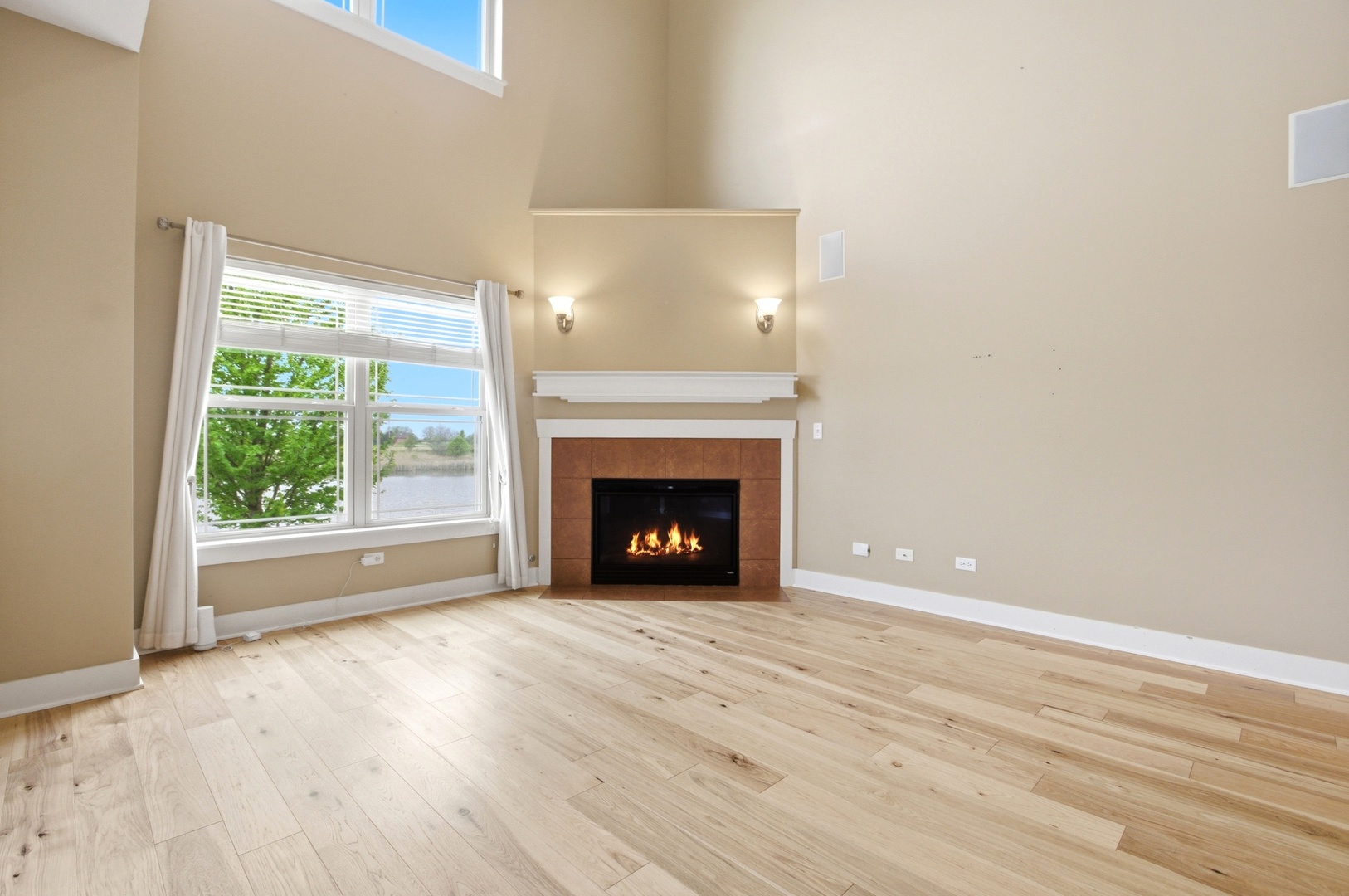15749 West Crobally Way Manhattan, IL 60442 - Photo 3 of 24 a view of an empty room with wooden floor fireplace and a window