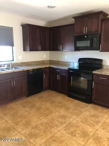a kitchen with granite countertop a stove a sink and a granite counter tops
