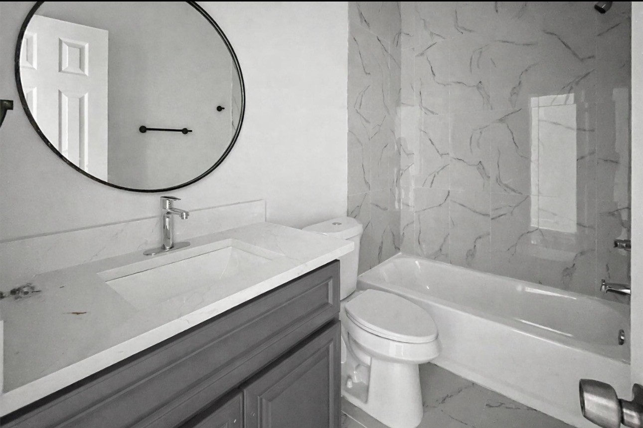 6010 Bobby Burns Street Houston, TX 77028 - Photo 15 of 22 a bathroom with a sink a toilet and a mirror