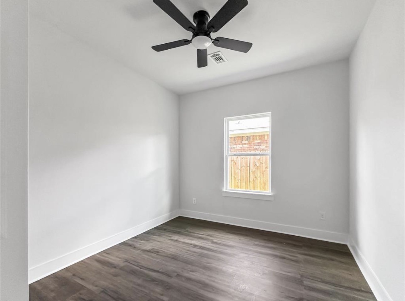 6010 Bobby Burns Street Houston, TX 77028 - Photo 18 of 22 an empty room with wooden floor chandelier fan and windows