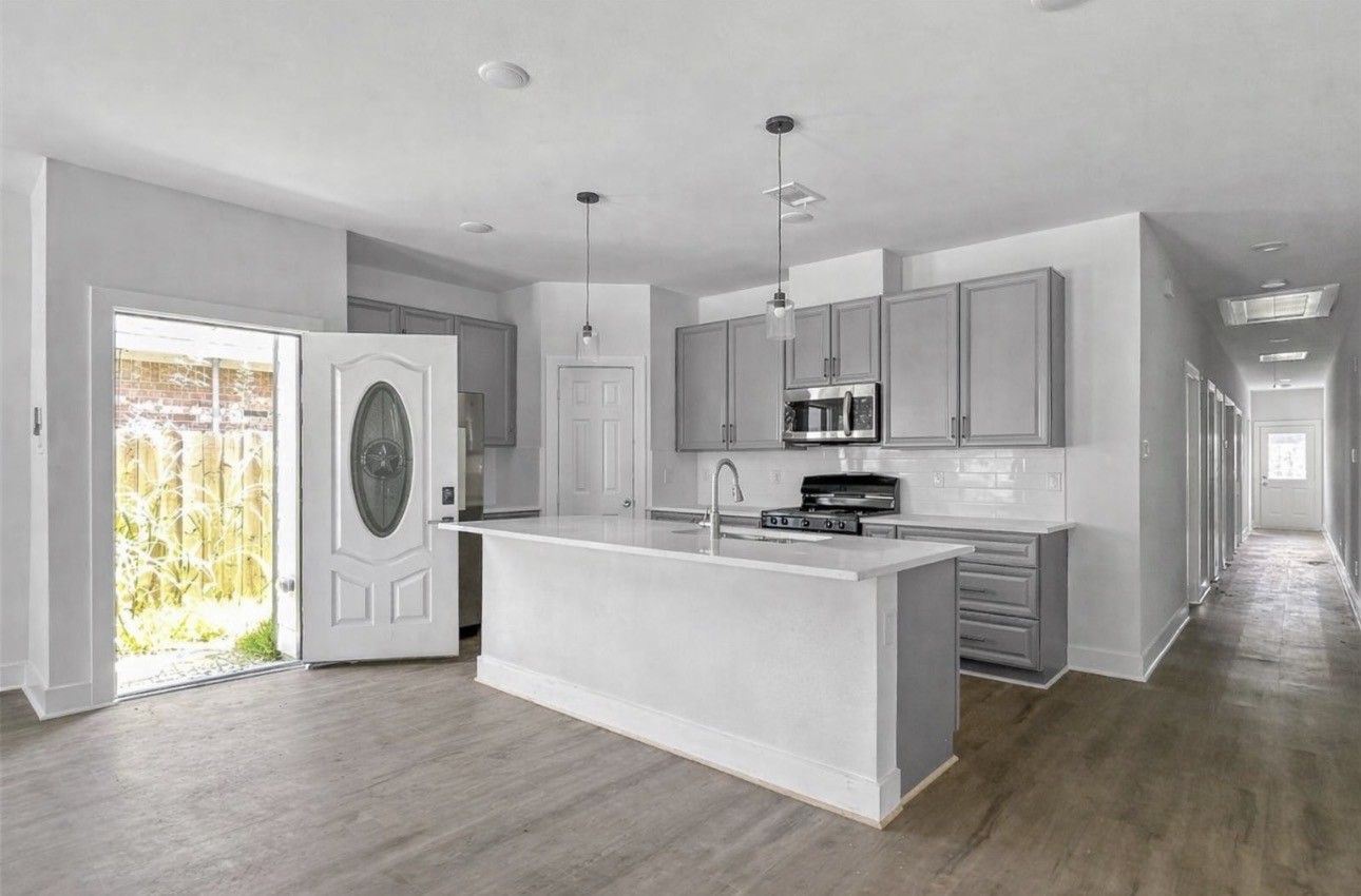 6010 Bobby Burns Street Houston, TX 77028 - Photo 6 of 22 a kitchen with stainless steel appliances granite countertop a stove a sink dishwasher a refrigerator white cabinets and wooden floor